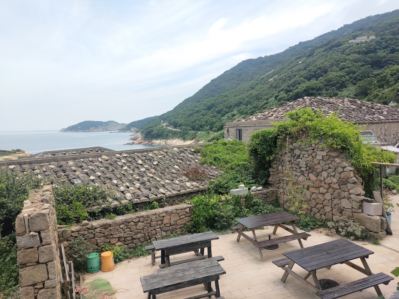 芹壁石屋與戶外木桌椅及山海景觀