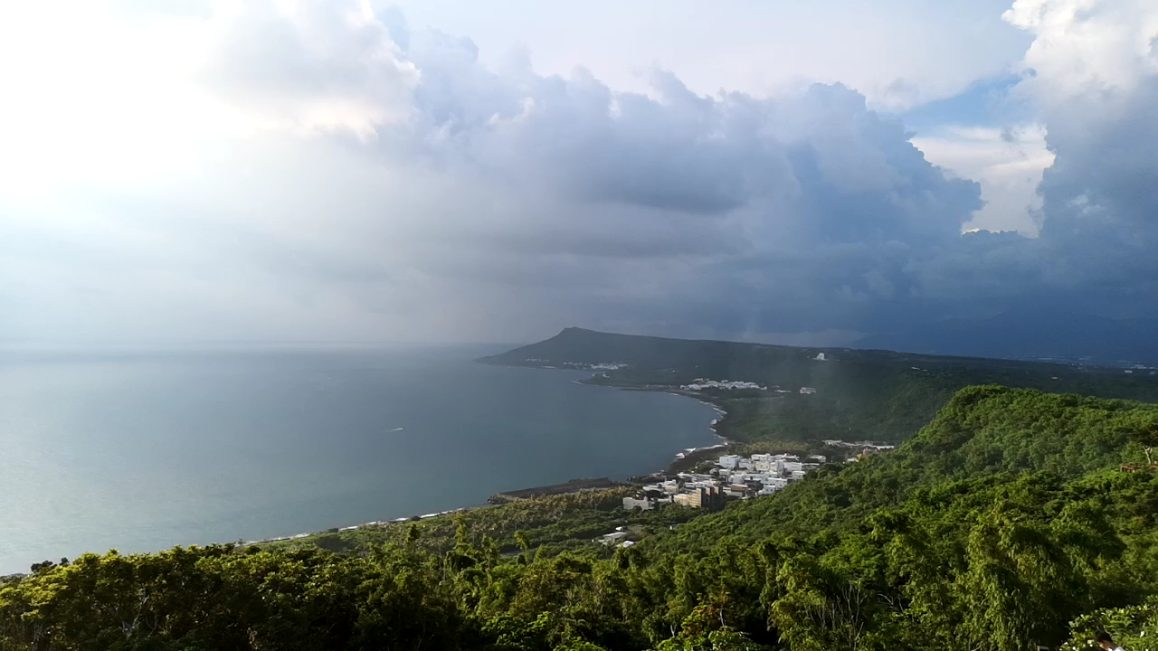 從關山頂俯瞰墾丁南灣全景，烏雲翻湧壯觀