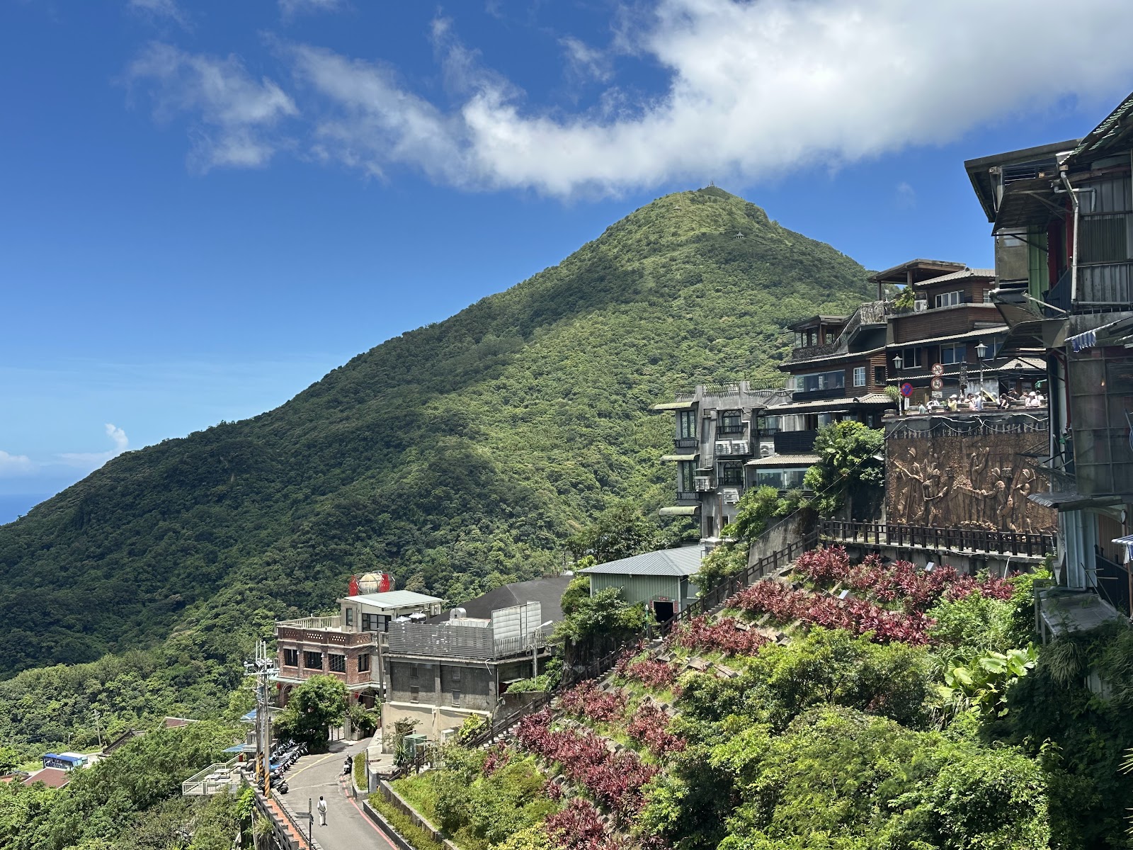 晴天俯望九份，翠綠山峰、藍天白雲、海灣遠景
