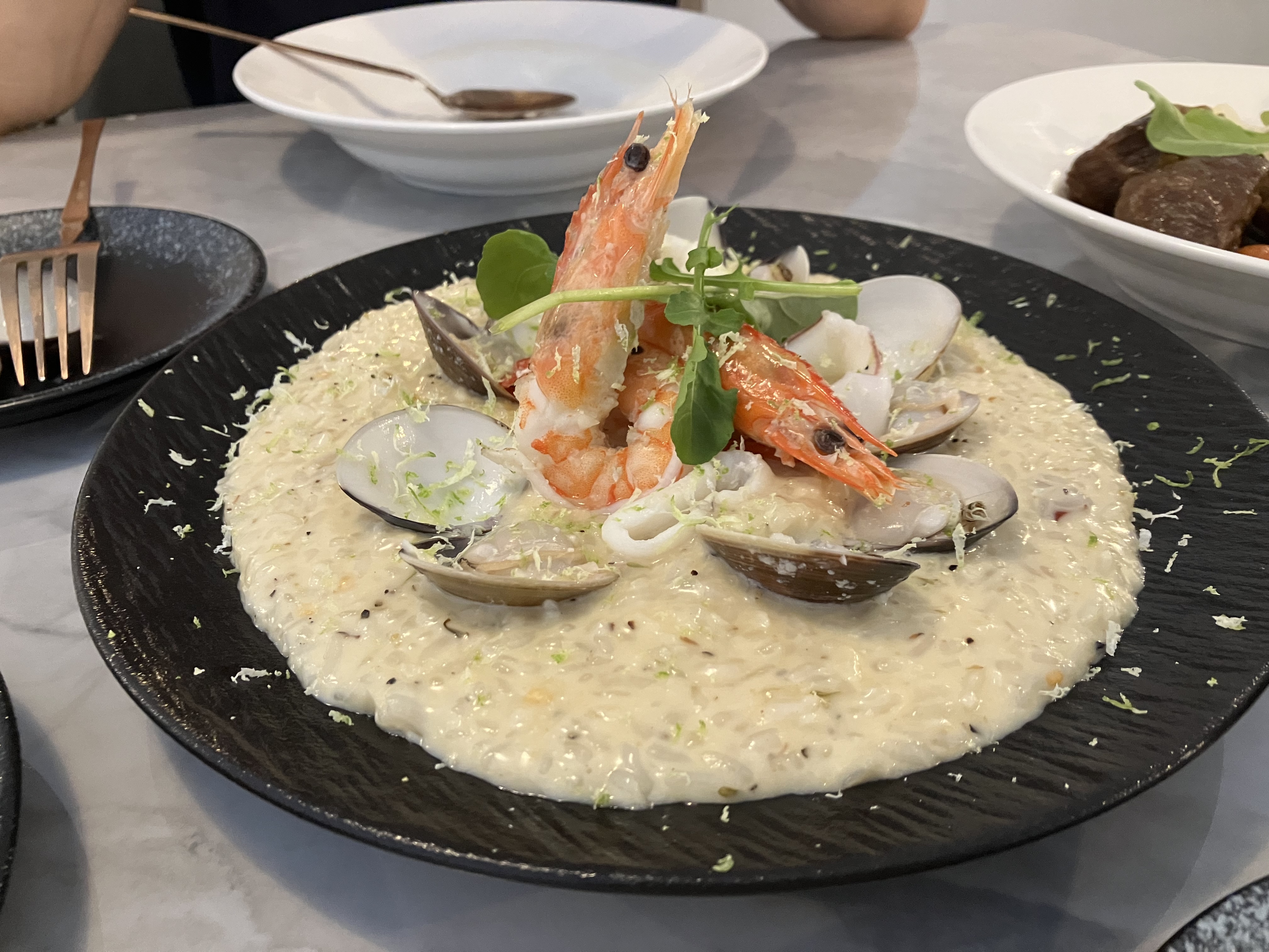 海鮮燉飯，上方有鮮蝦與蛤蠣