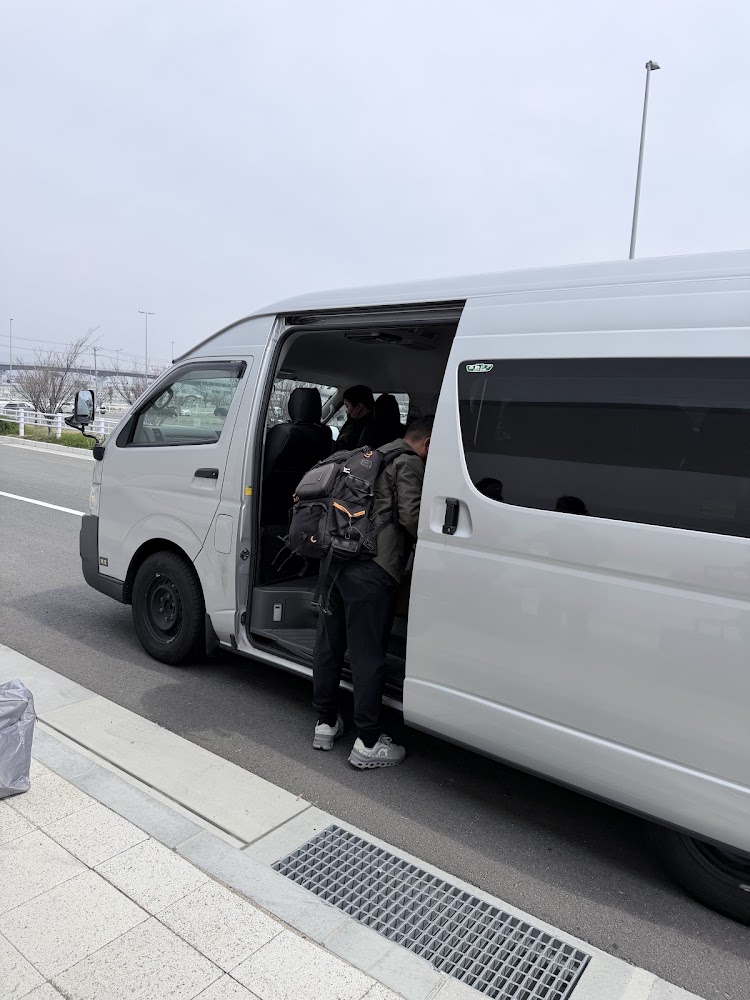 白色廂型車停靠路邊乘客準備上車
