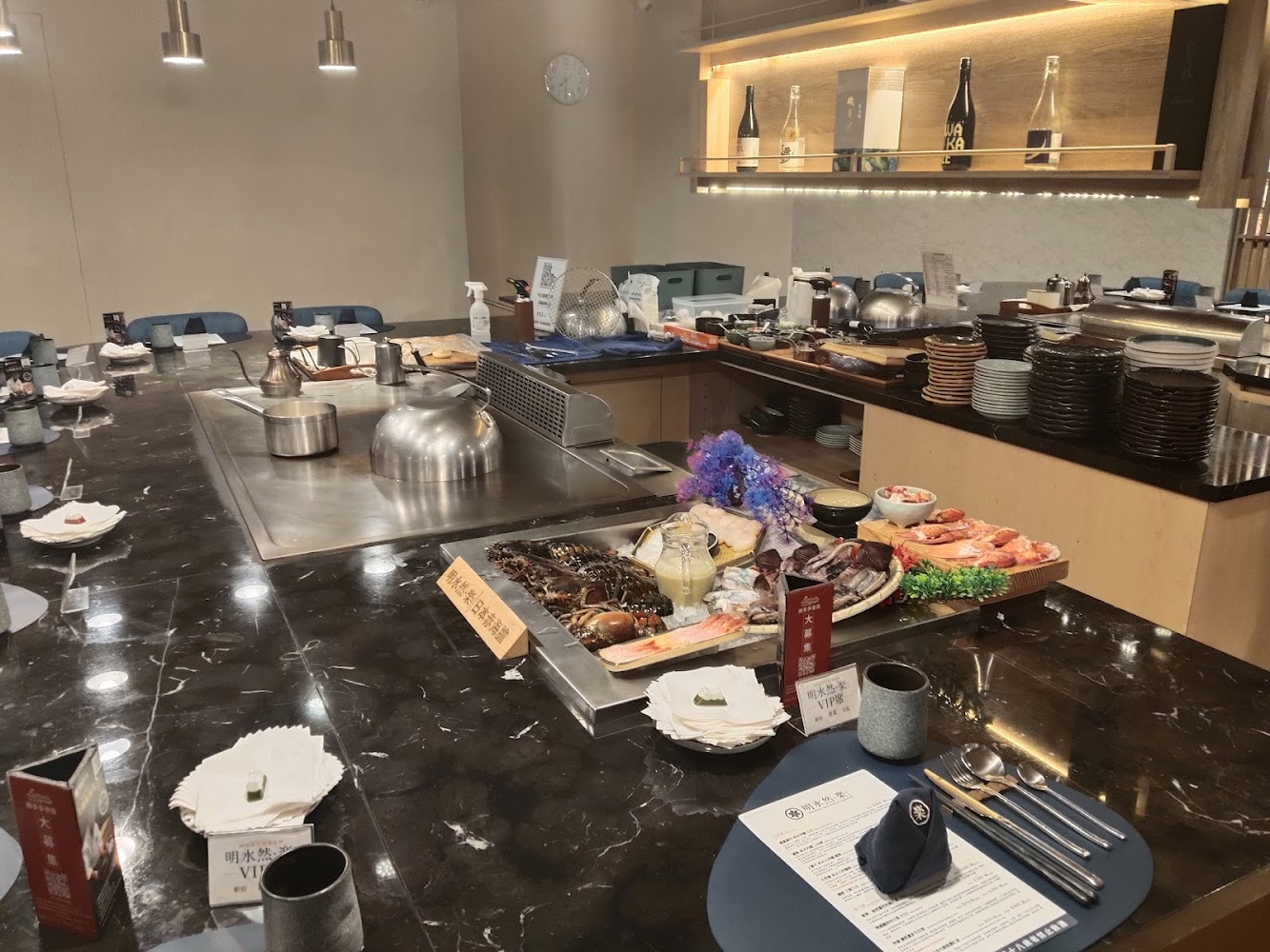高級鐵板燒餐廳的中央料理台展示新鮮海鮮，四周圍繞座位