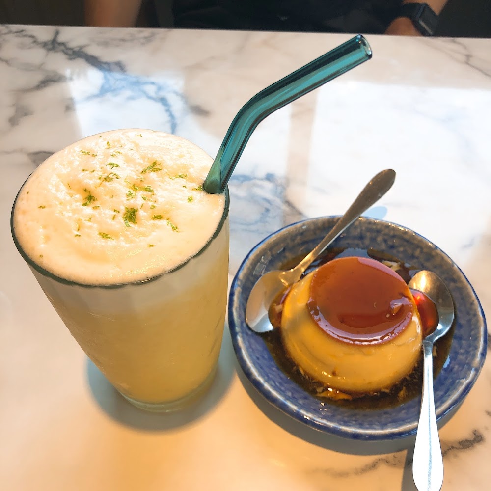 奶泡飲品搭配藍色小碟焦糖布丁的精緻午茶組合