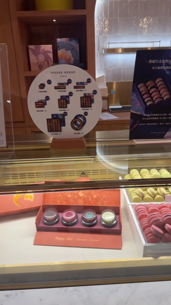 甜點店櫥窗展示精美包裝馬卡龍禮盒與多種顏色馬卡龍
