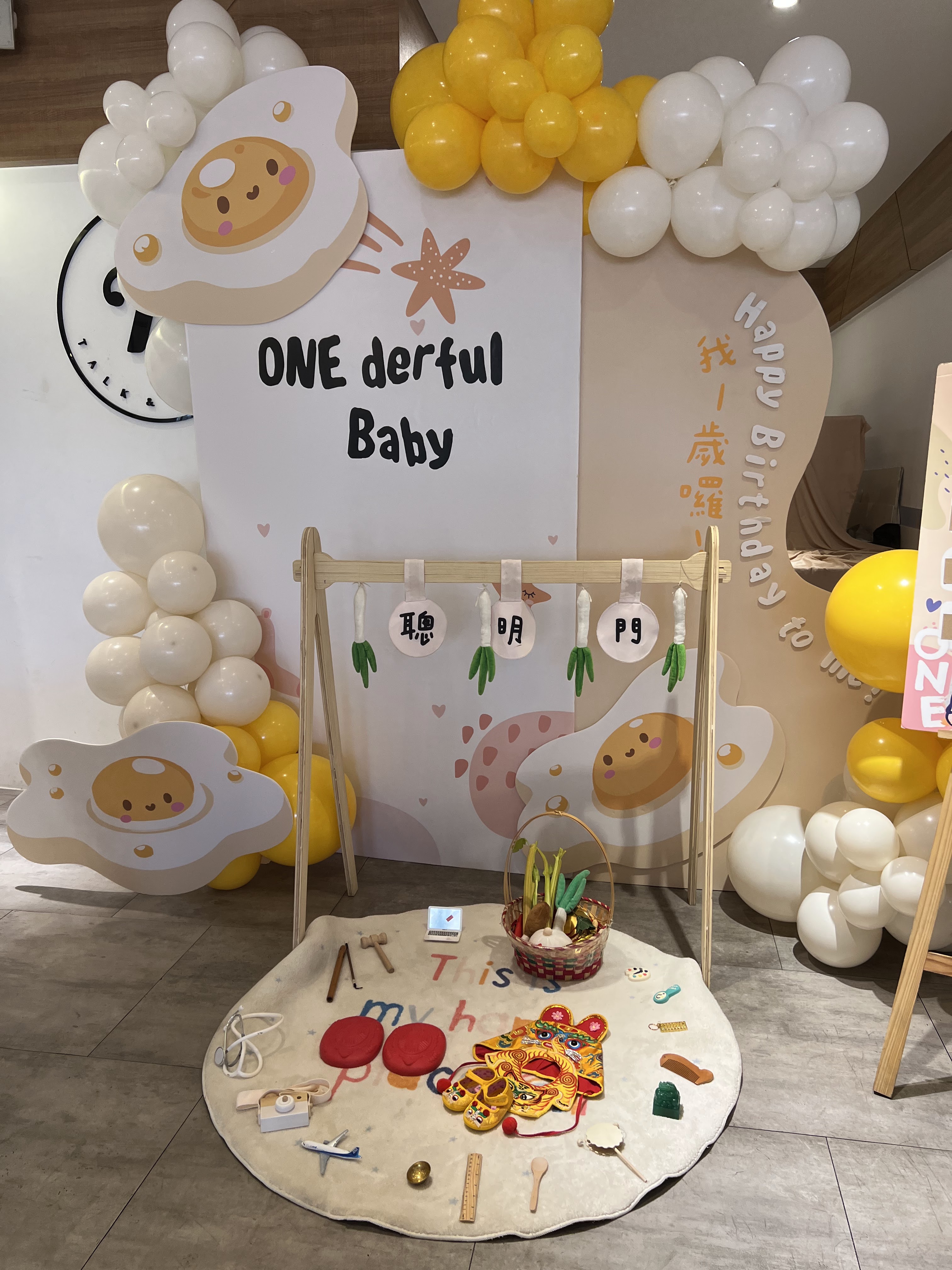 嬰兒一歲生日抓周活動現場，有氣球佈置與抓周道具