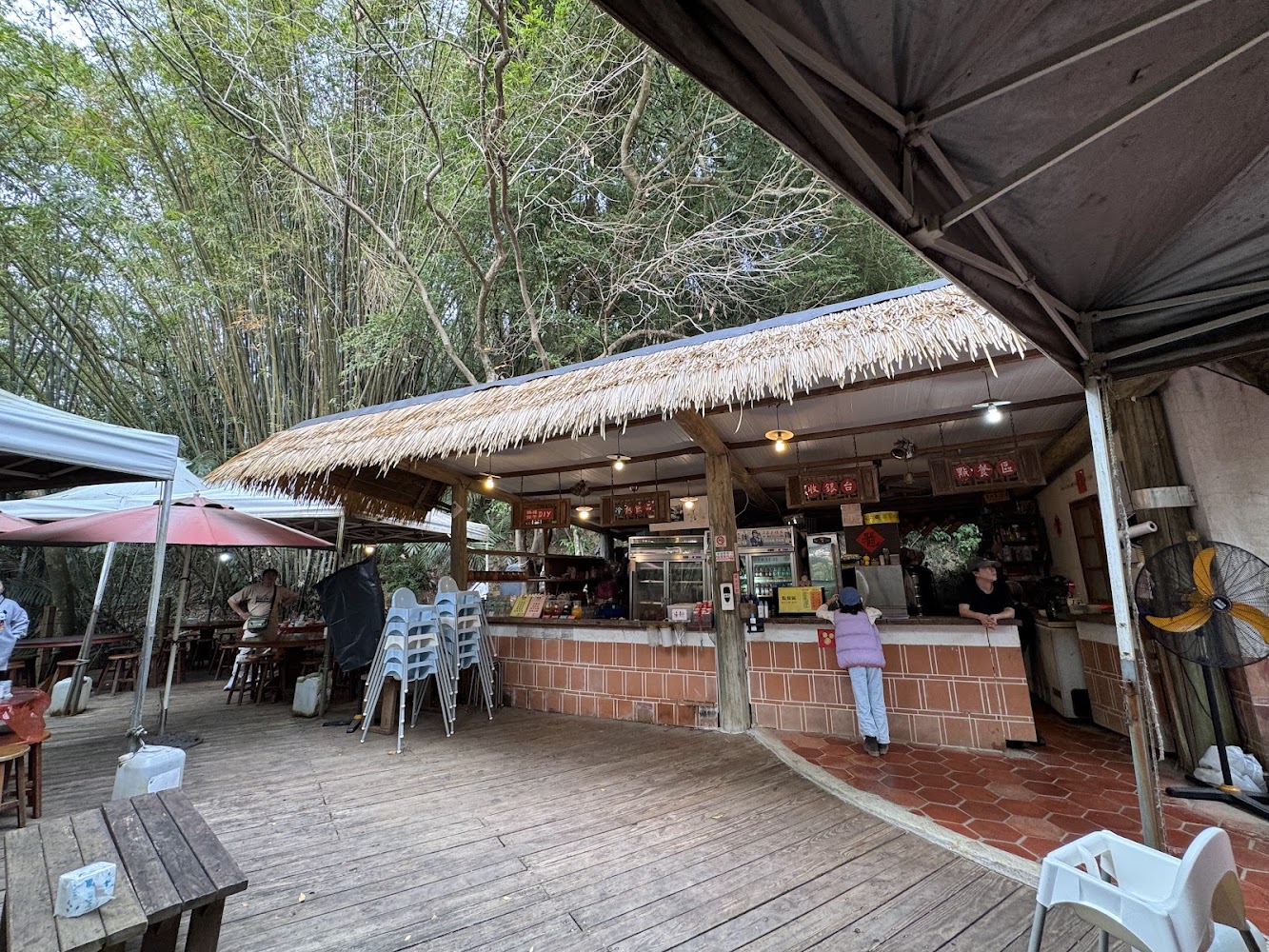 百年古厝客家餐廳戶外竹林旁用餐區與茅草屋頂