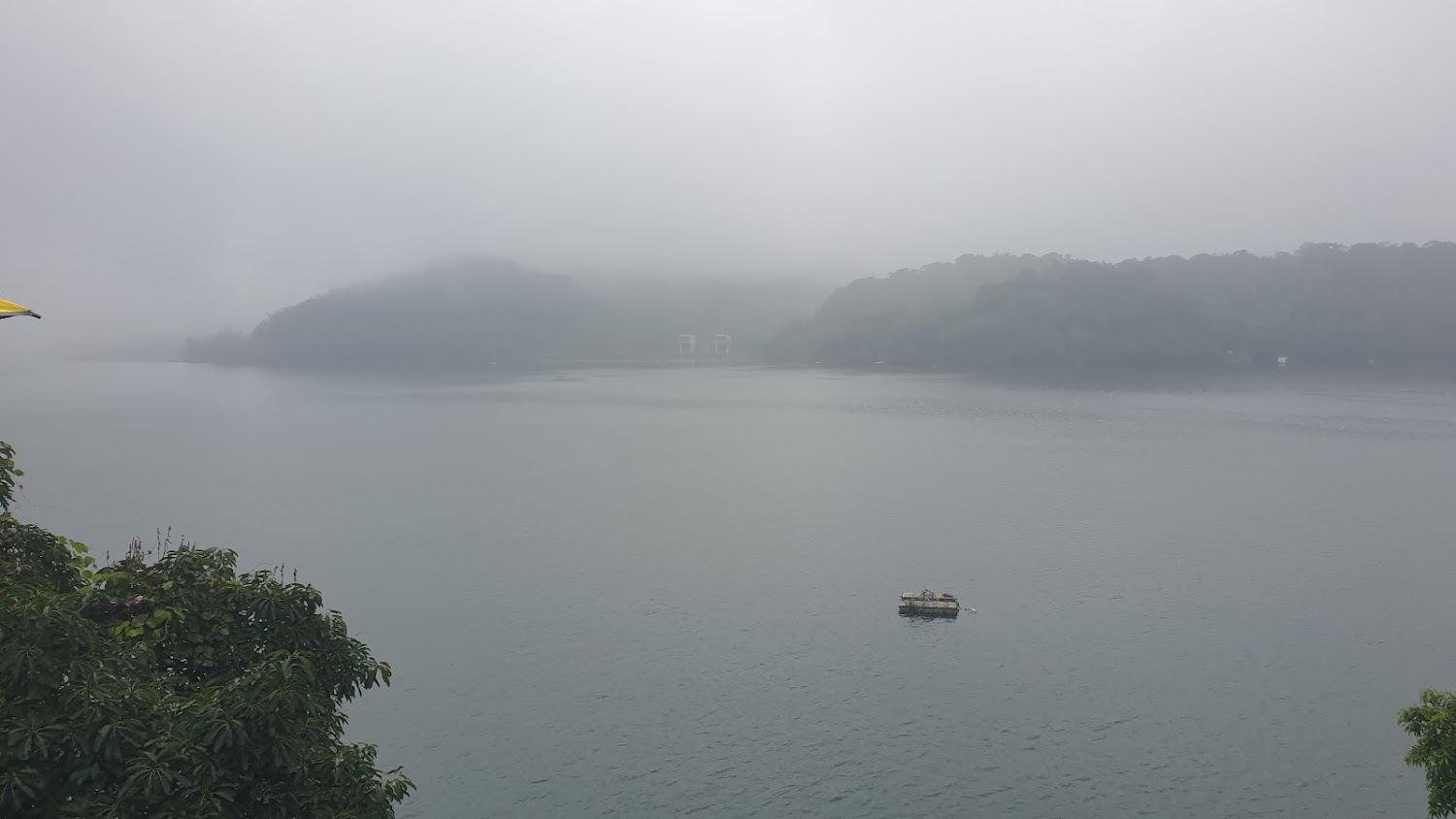 濃霧籠罩的湖泊與小木筏景色寧靜神秘