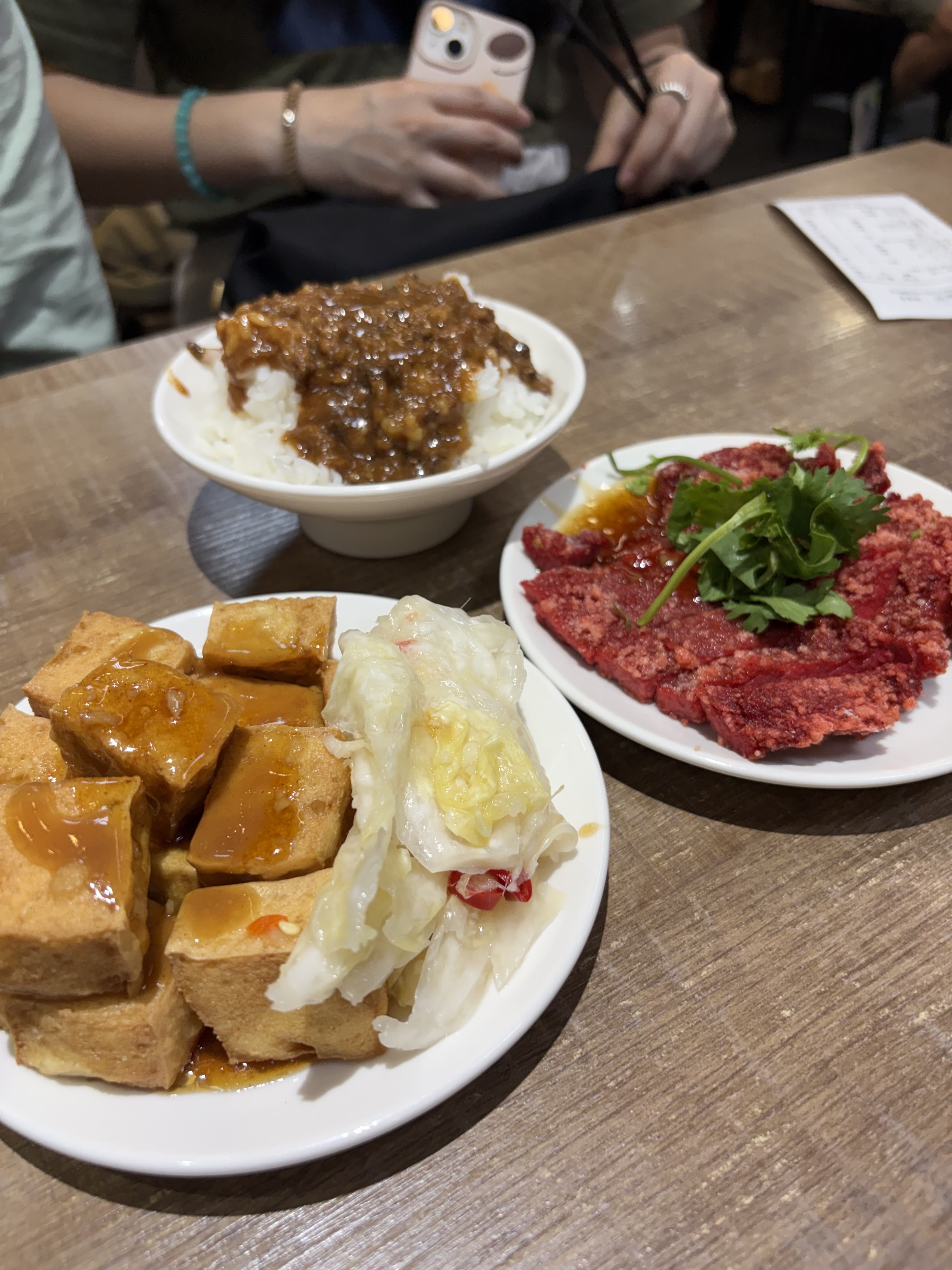 中山五十六桌上有滷肉飯、炸臭豆腐與生牛肉等台式小吃