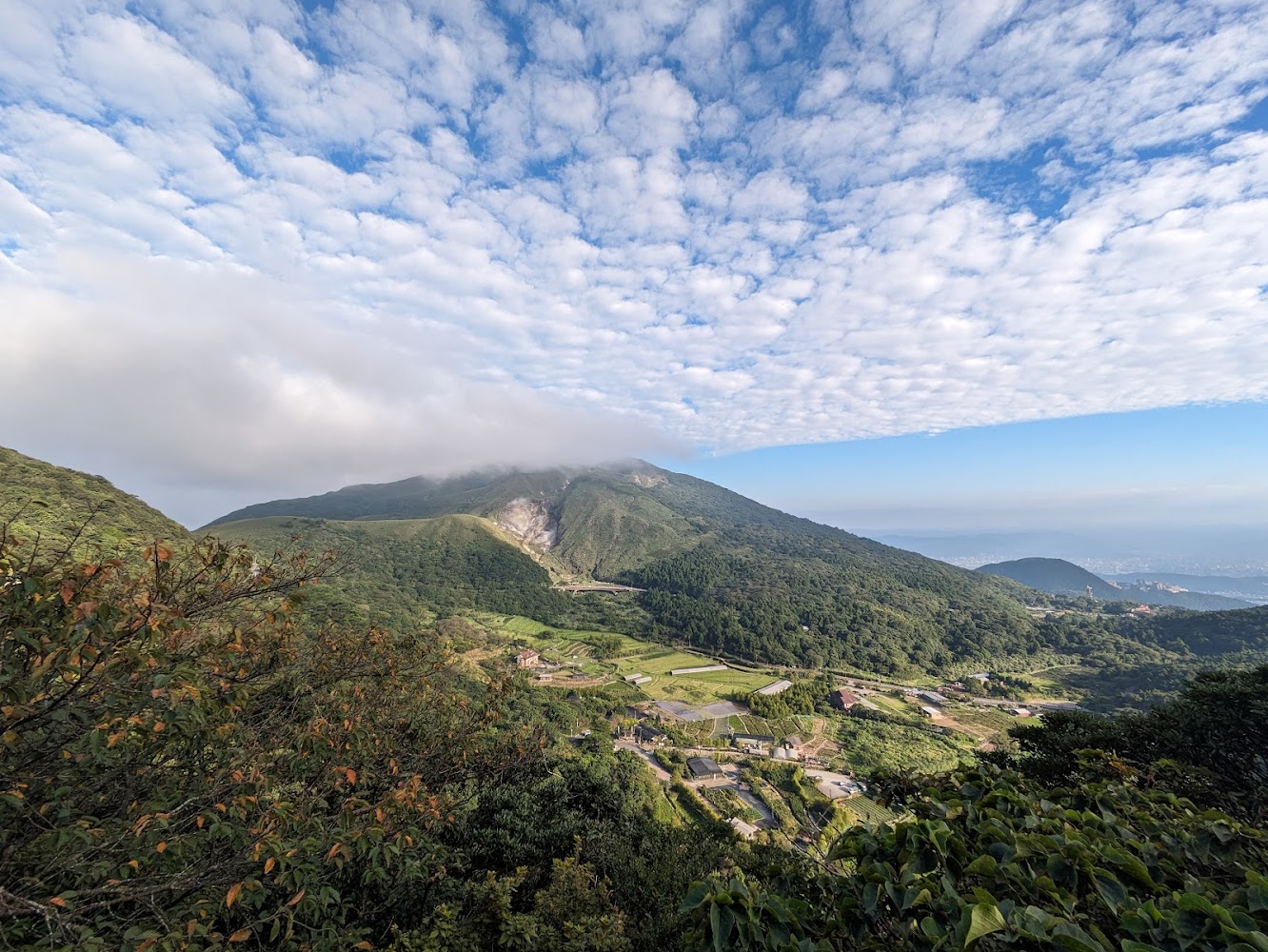 壯觀山景藍天與山下農田房屋