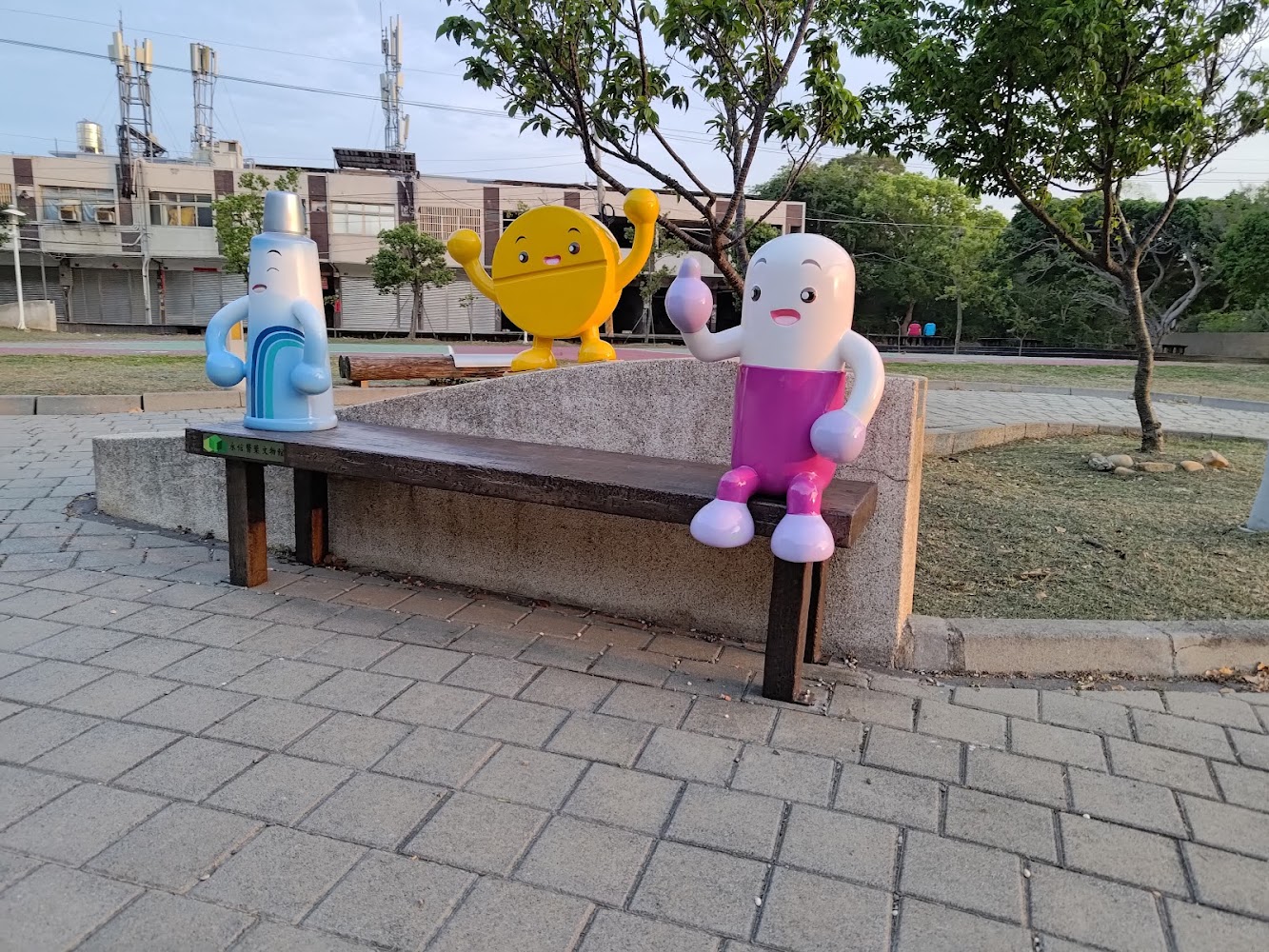 公園長椅上有三個擬人化卡通裝置造型可愛