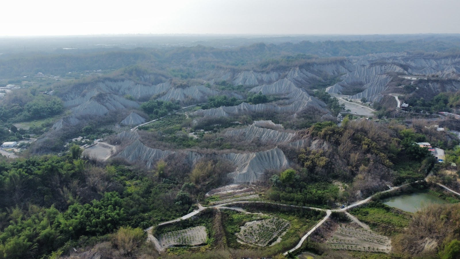 高雄田寮月世界步道空拍大範圍俯瞰，泥岩群山農田道路交錯