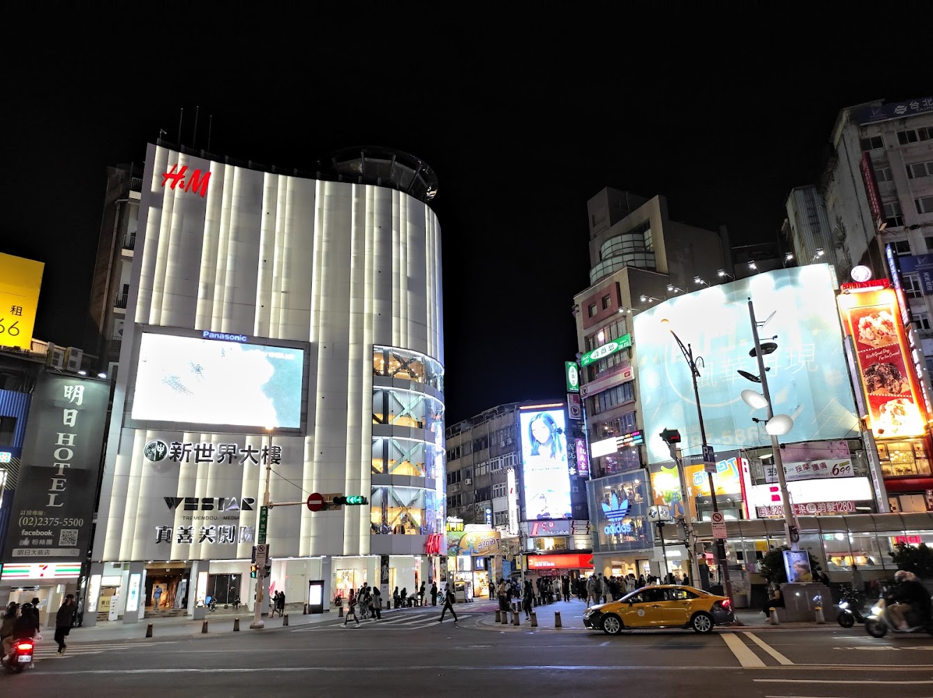 外牆有H&M標誌的大型購物大樓與夜間街景