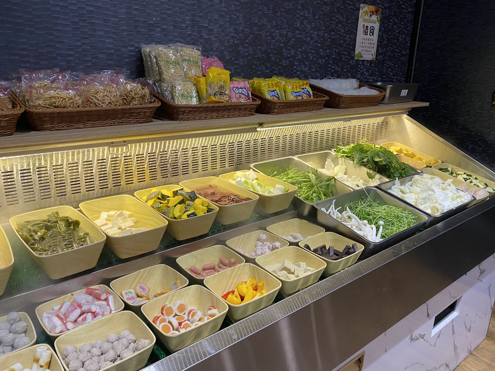 誠石火鍋西螺店自助蔬菜吧台，擺滿豆腐、貢丸、各式青菜