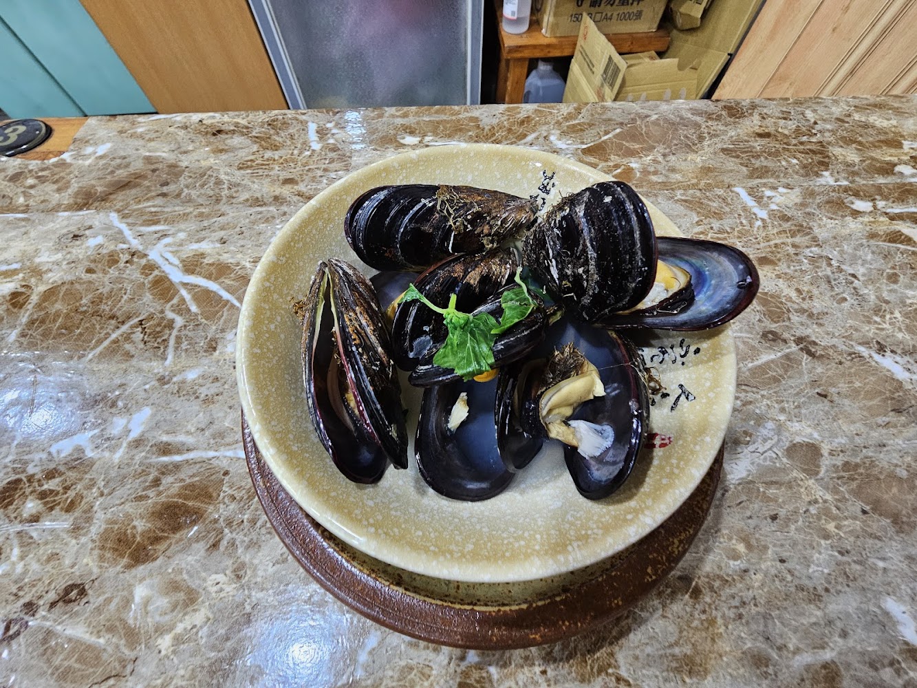 一盤新鮮貽貝料理擺在桌面上
