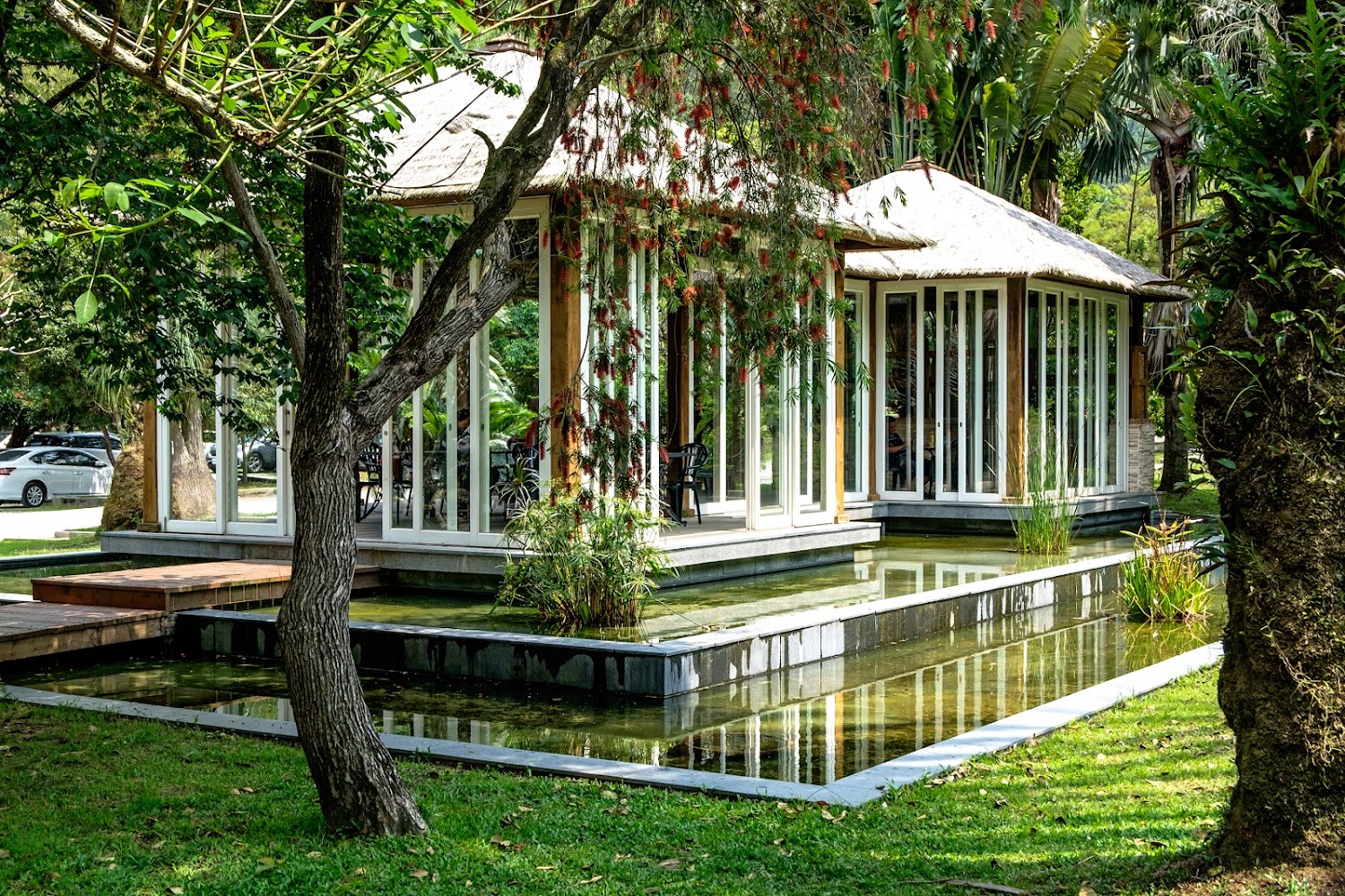 玻璃建築與草坪水池構成的現代庭園景色
