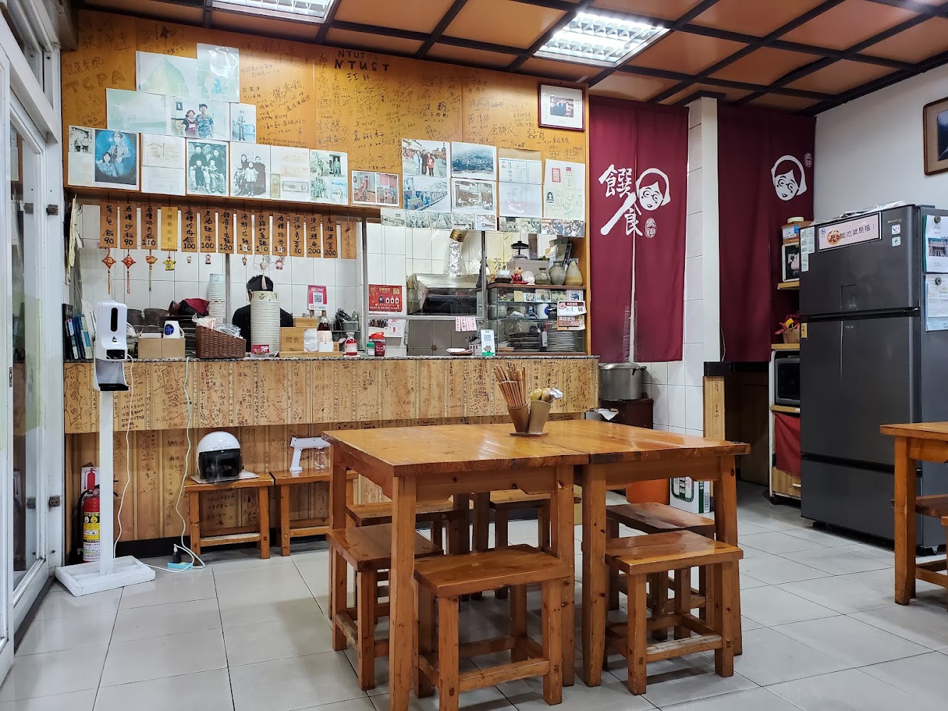 店內有木製桌椅與牆上照片留言，氛圍溫馨親切