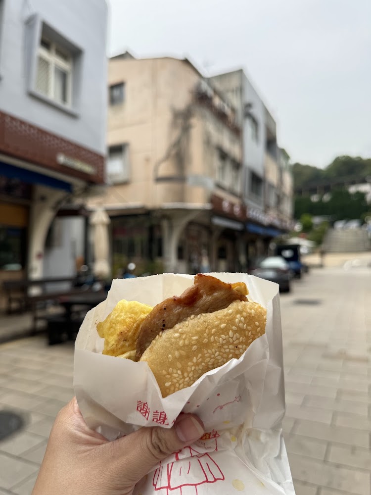 手拿芝麻燒餅夾蛋和肉餡