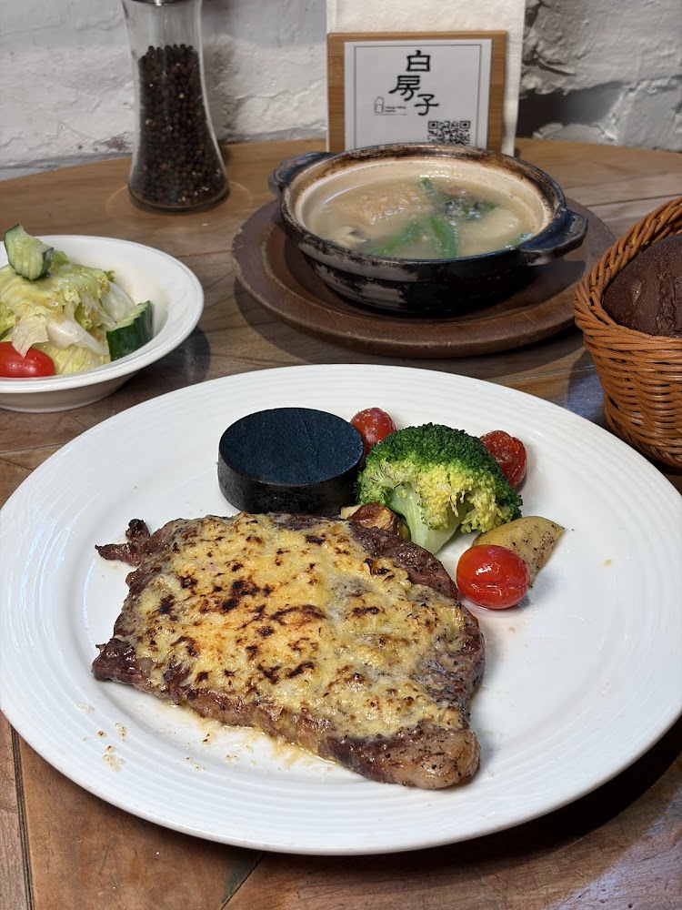 白房子主餐盤包含牛排與沙拉麵包等配菜