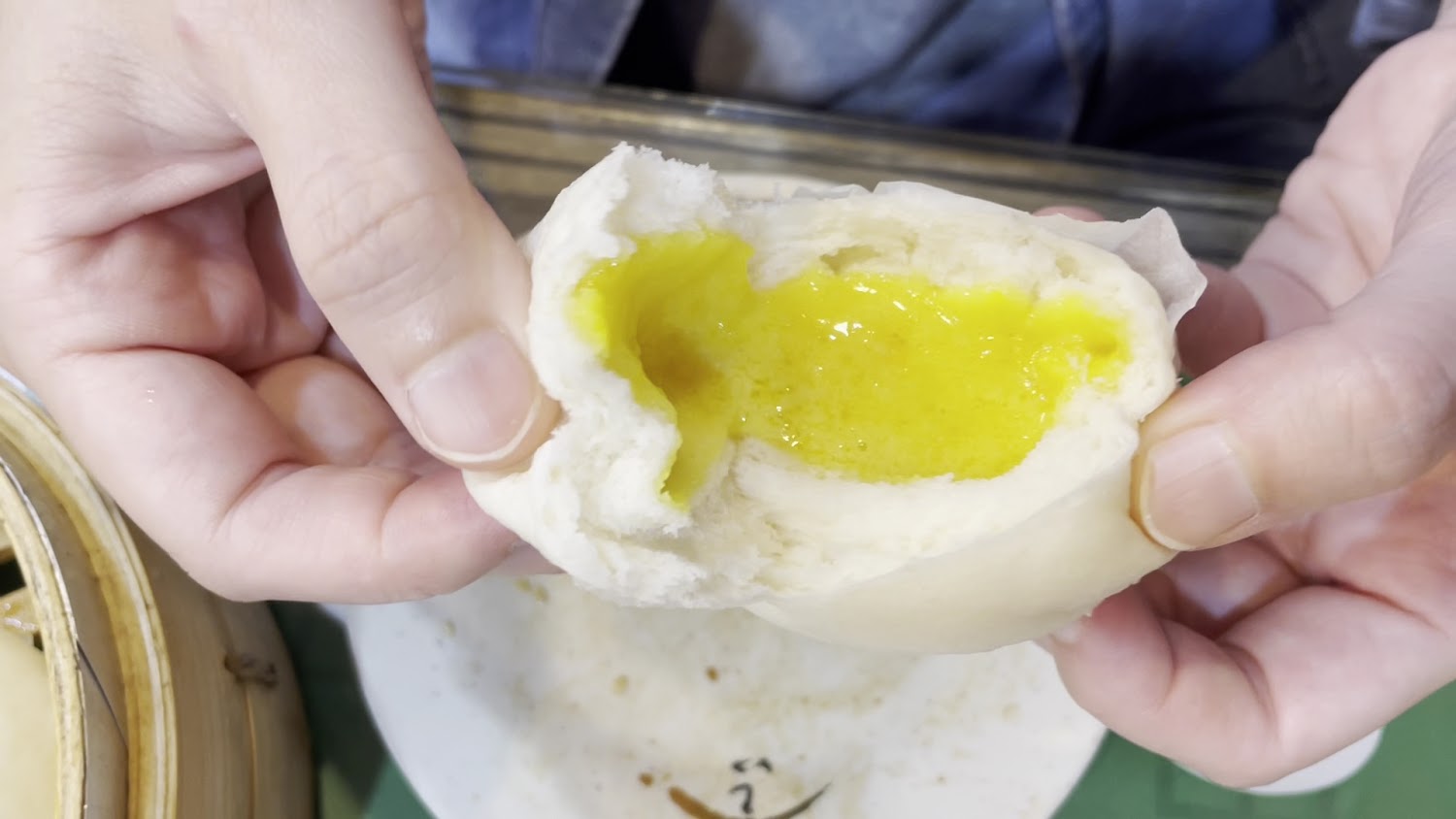 奶黃包剝開後內餡金黃流心，外皮鬆軟誘人