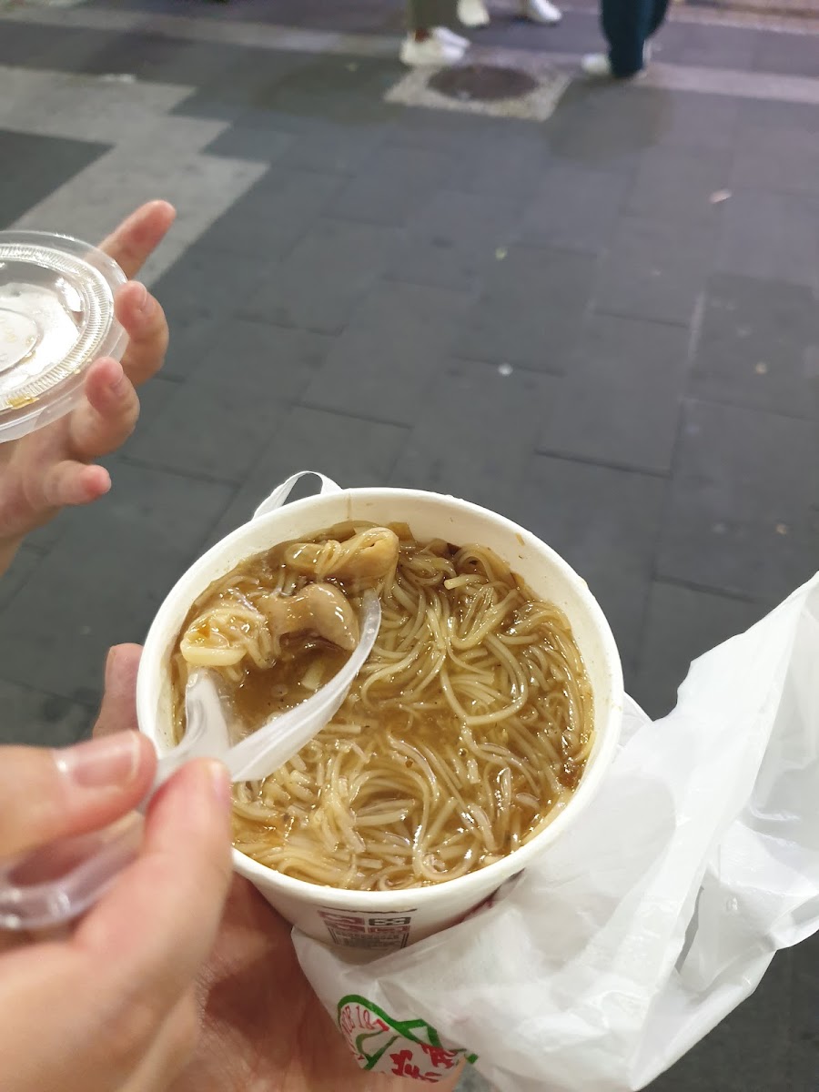 阿宗麵線外帶紙碗，手持一碗麵線在街道行走