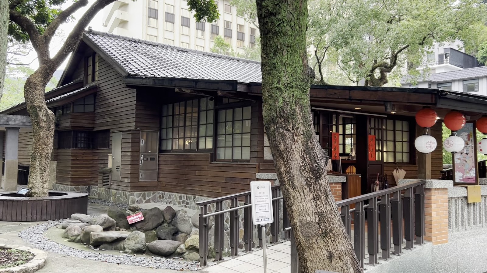 梅庭木造建築近景，入口廊道掛有紅燈籠增添傳統氛圍
