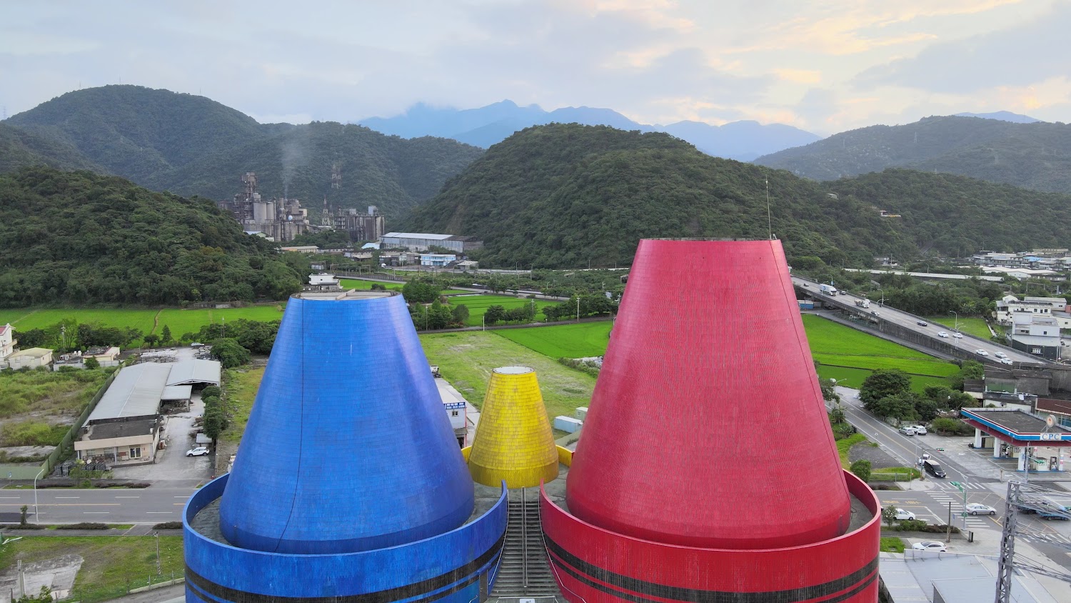 藍紅黃三個巨大彩色錐形建築位於山區