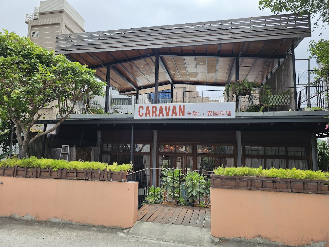Caravan 卡騯異國料理外觀，兩層樓木質建築搭配大量綠色植栽