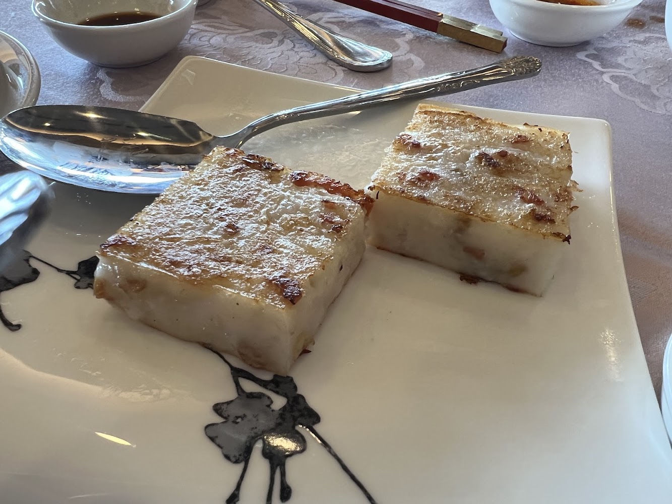兩塊金黃香脆蘿蔔糕放在白色餐盤上