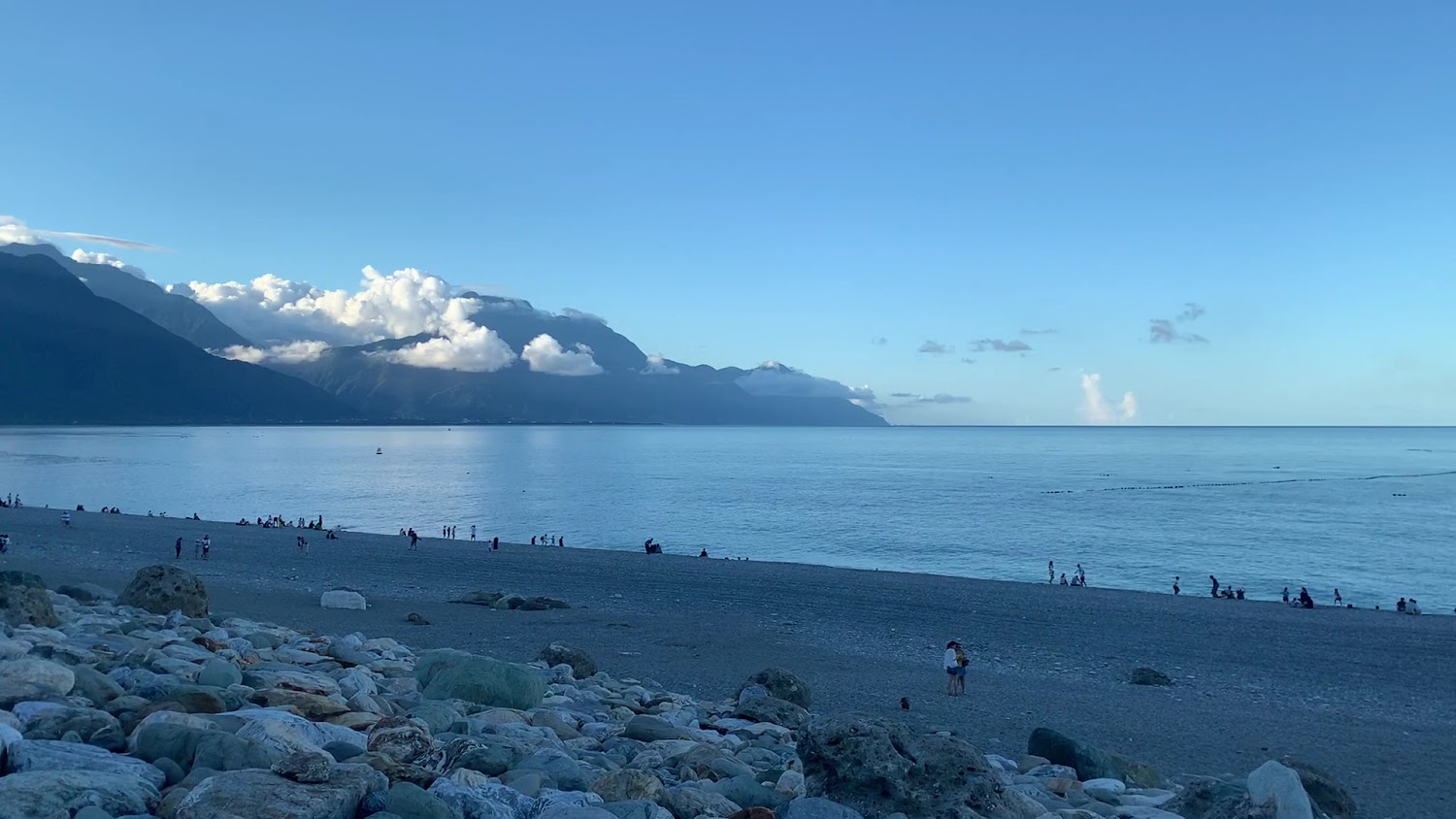 大片藍天海洋與山脈背景下的七星潭鵝卵石海灘