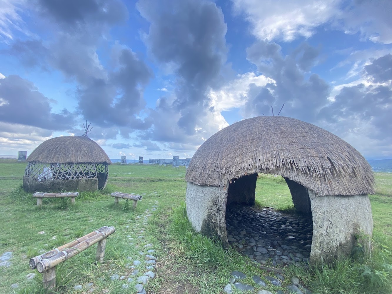 茅草圓頂小屋與草地小徑藍天