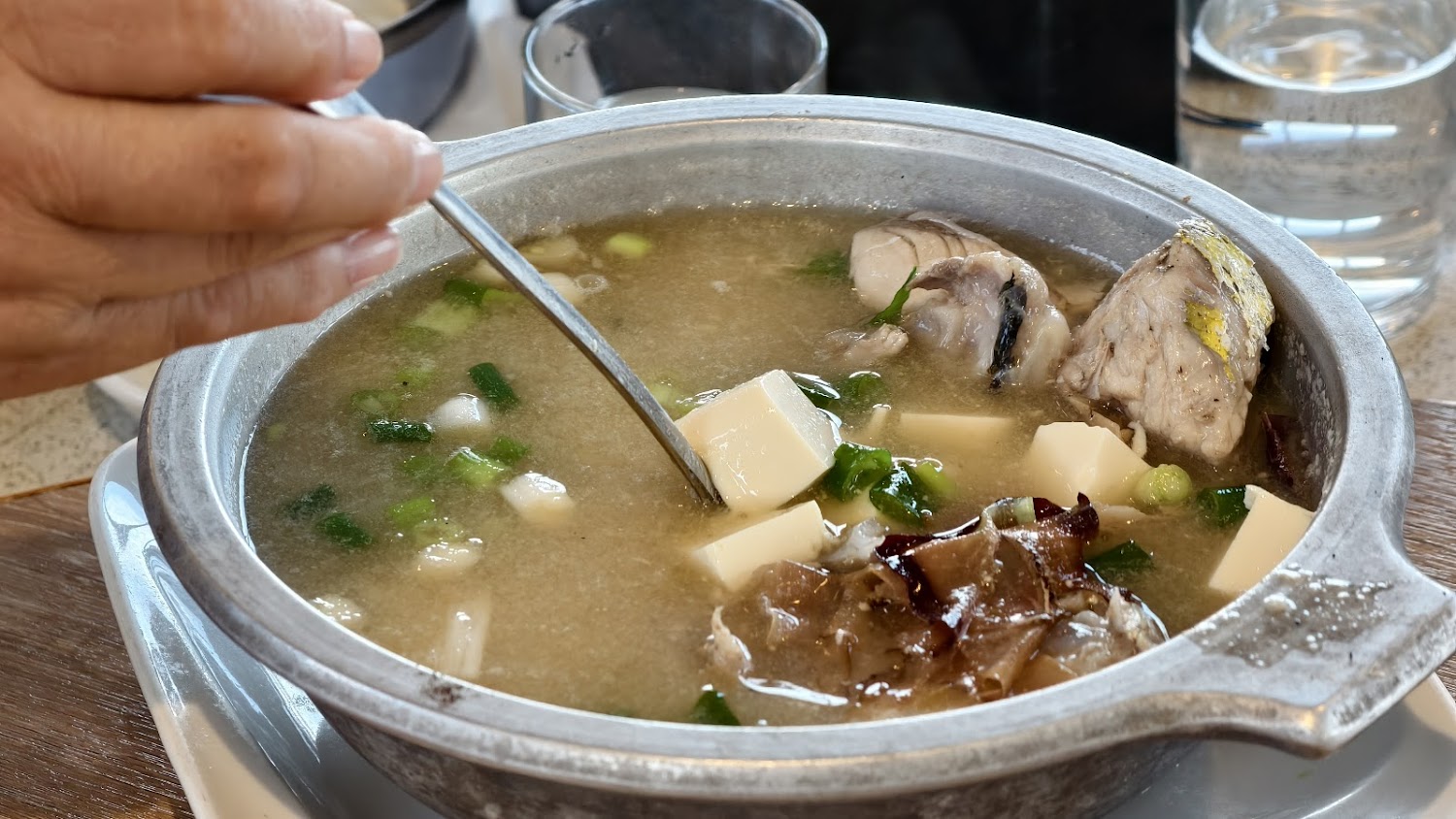 熱騰騰的魚頭豆腐湯，配料有魚頭嫩豆腐木耳與蔥花