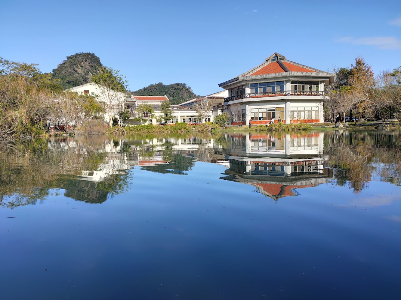 現代建築倒映在寧靜湖面與山景
