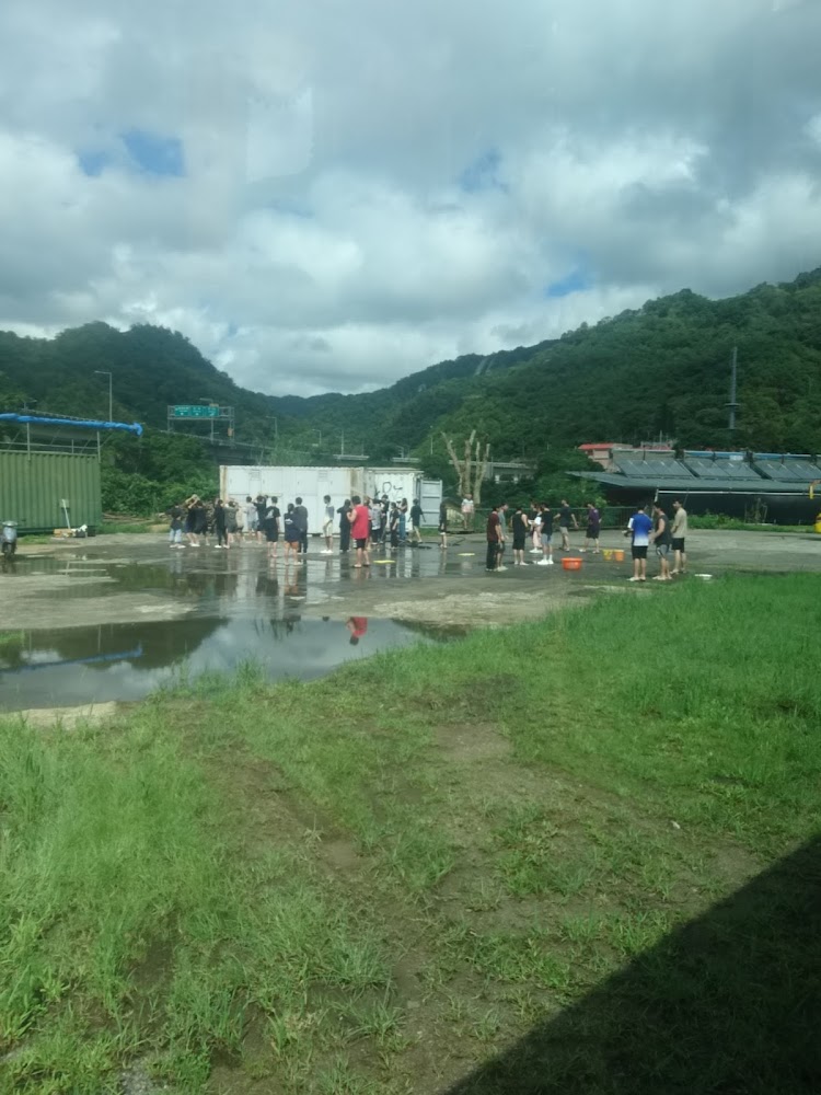 戶外空地聚集人群與山景天空