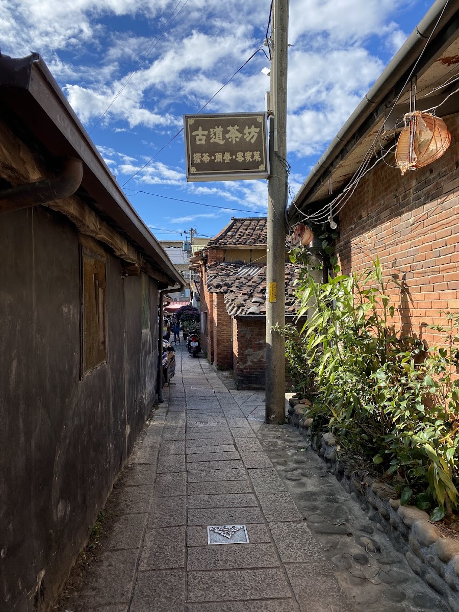 內灣老街古樸小巷，紅磚牆，「古道茶坊」招牌，石板地，藍天