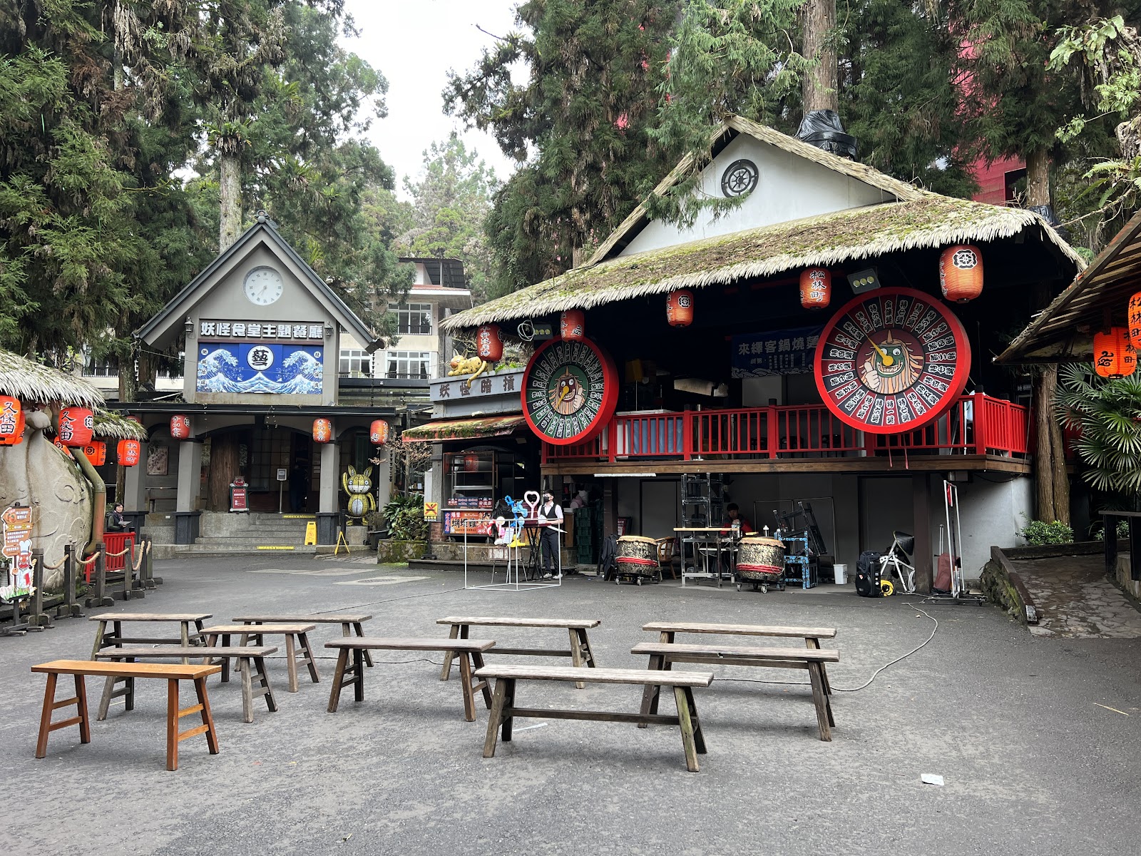 妖怪村商圈廣場，日式草屋頂木造建築群，高掛紅燈籠與大風車裝飾