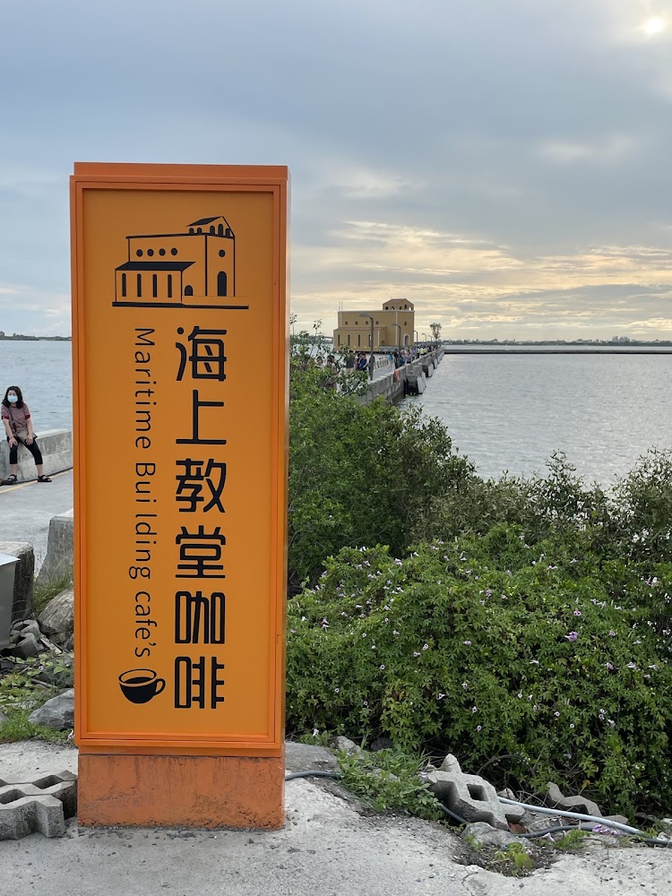 橘色招牌與通往海上建築的長堤夕陽景色
