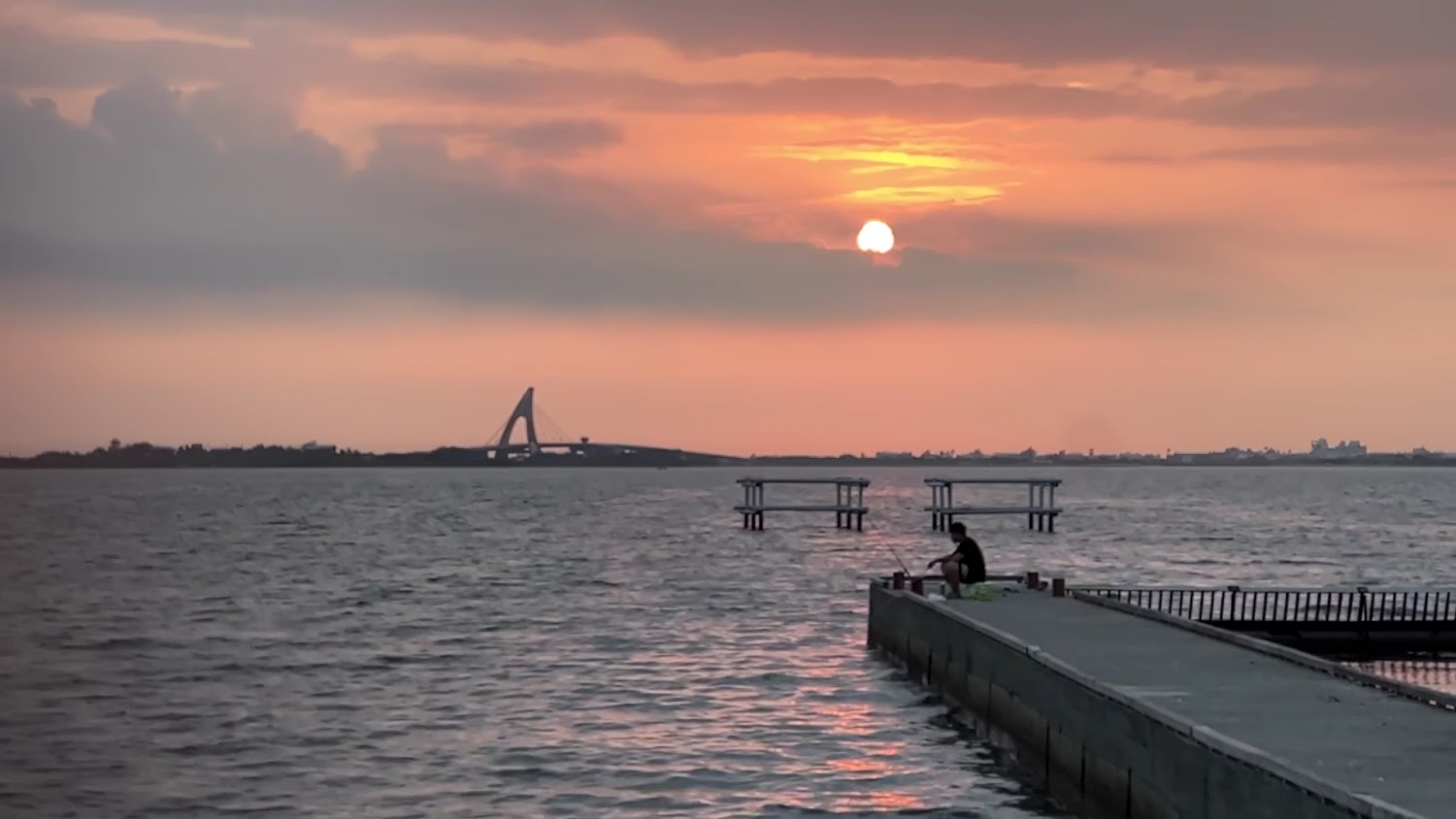 夕陽海邊與橋樑及釣客