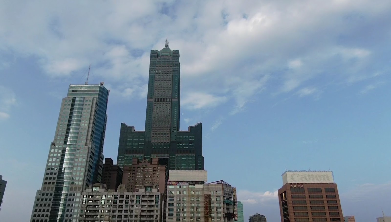 從街道仰望高雄85大樓，周邊現代都市背景