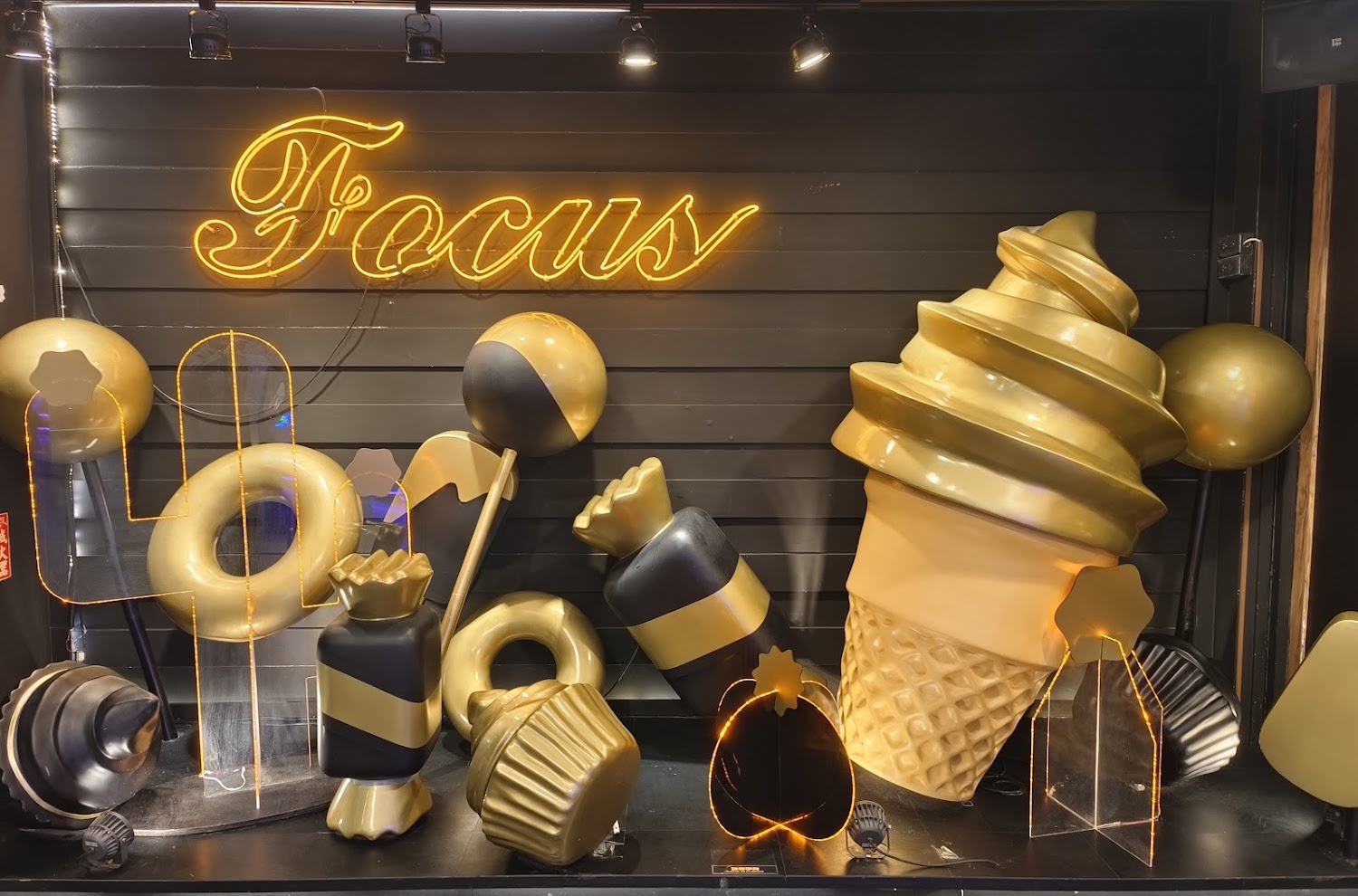 以金色黑色為主的FOCUS甜點主題打卡裝飾與霓虹燈