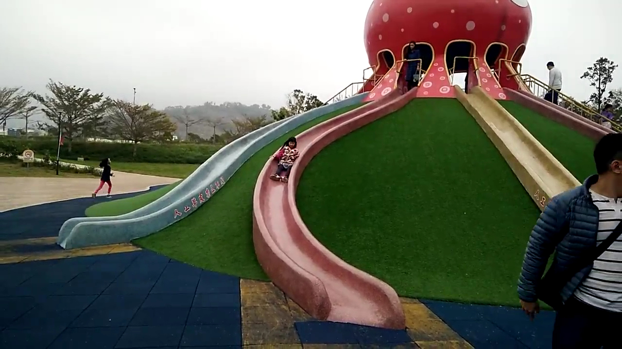 貓裏喵親子公園紅色章魚蘑菇造型大型溜滑梯，小孩正在溜滑梯