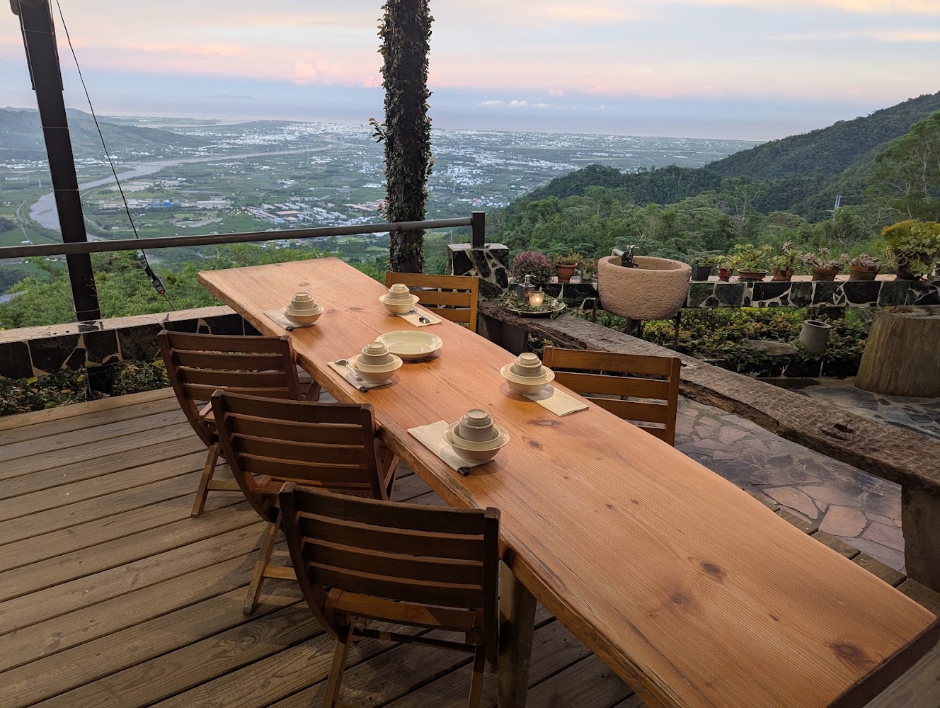 面對山景的戶外木桌椅桌上擺有餐具