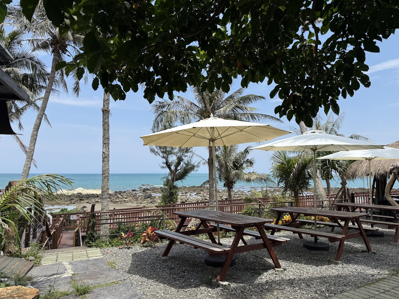海邊桌椅白色遮陽傘與棕櫚樹