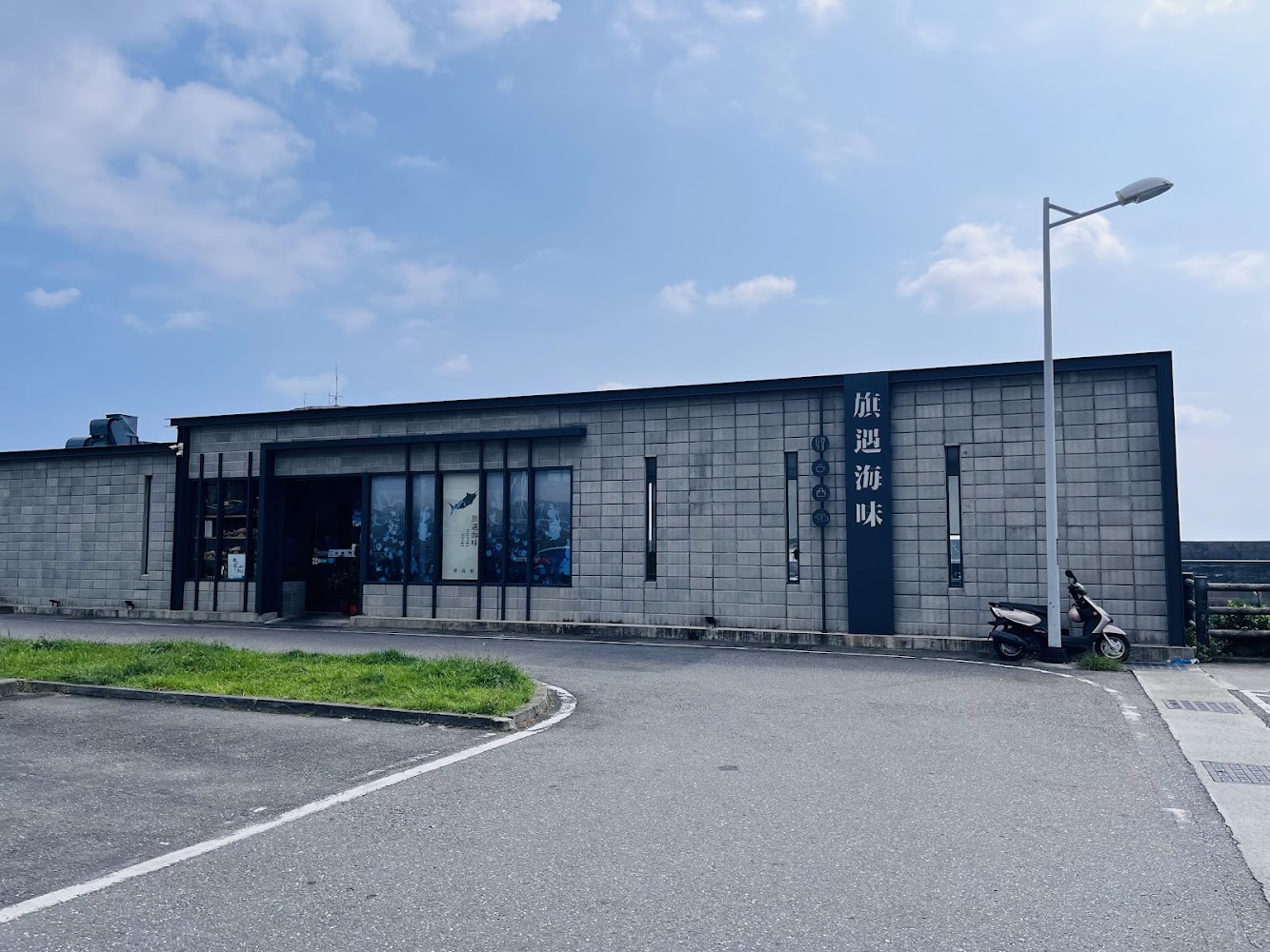 旗遇海味灰色現代建築與招牌，周邊環境清爽