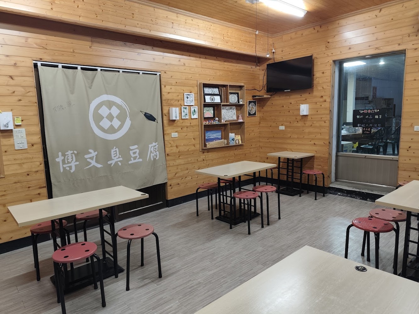 博文臭豆腐內用區有木桌紅色圓凳與布簾