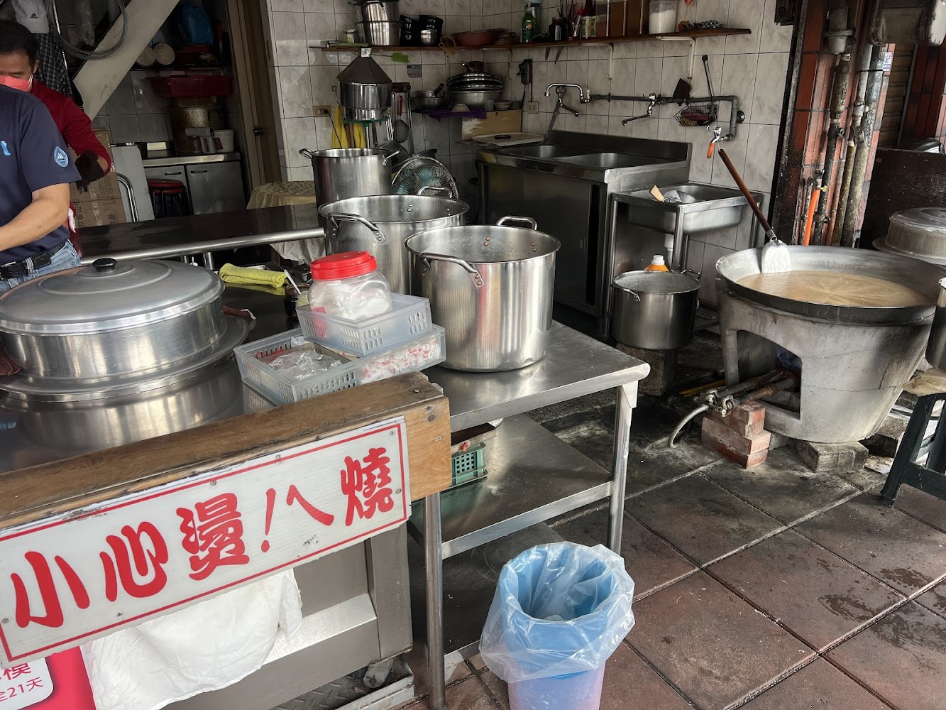 傳統小吃店廚房有湯鍋、不鏽鋼桌面與警告標語