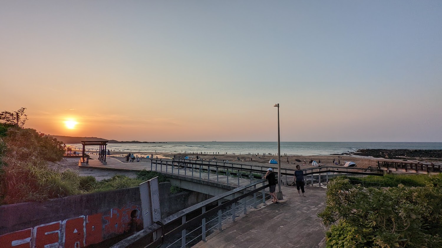 夕陽下的海灘與涼亭、步道、植栽景色