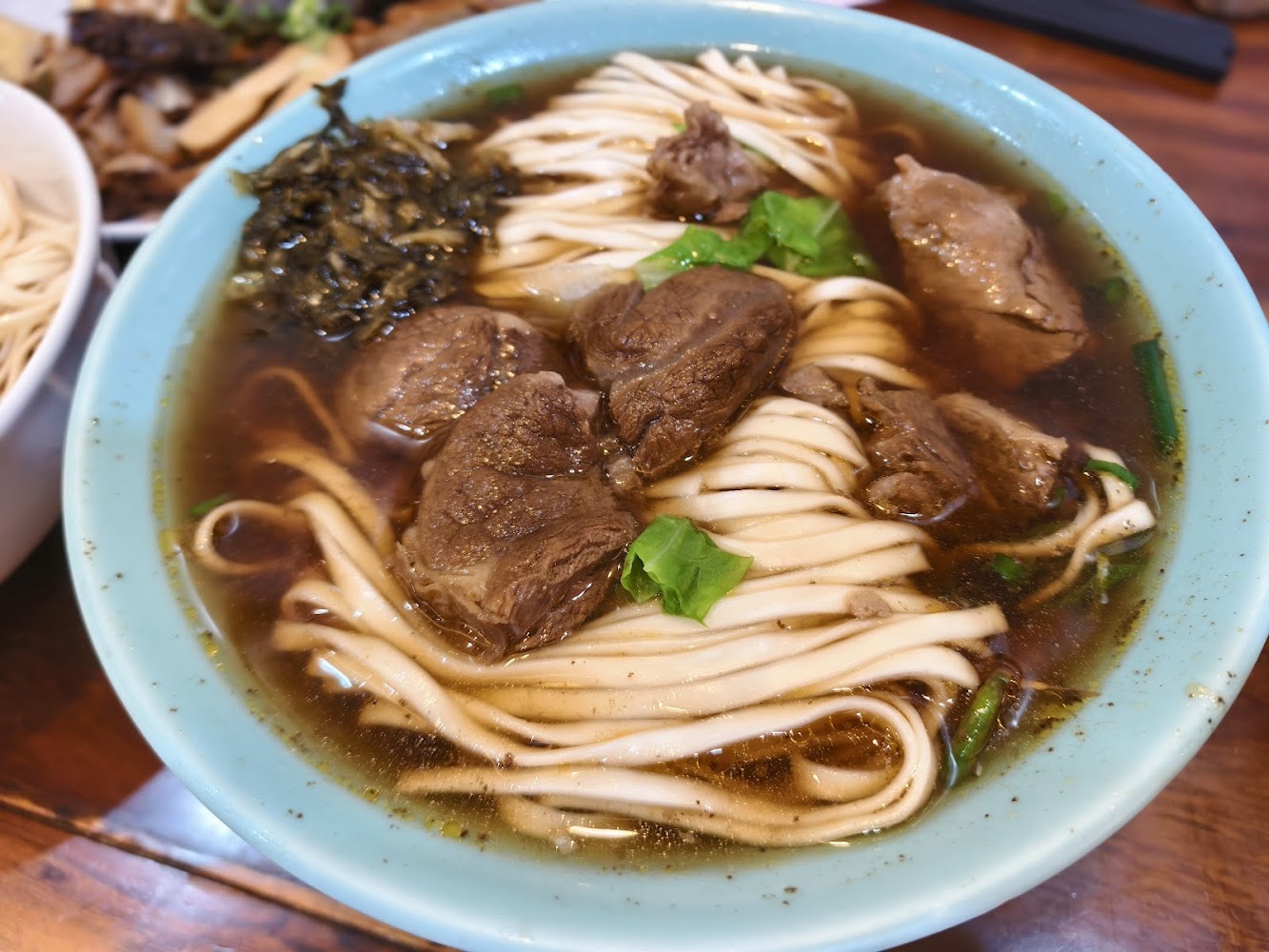 清燉風格牛肉麵，寬麵與多塊牛肉搭配清澈湯頭