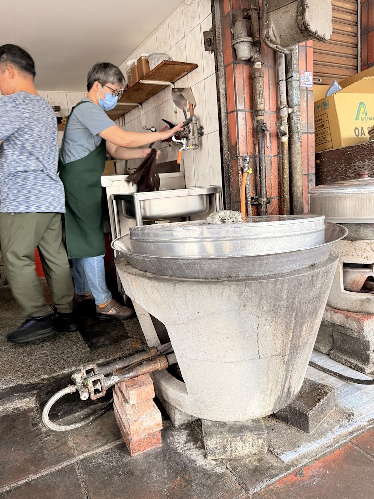 傳統小吃店廚房有大型蒸鍋與工作人員忙碌準備