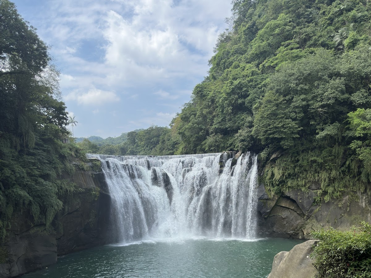 十分瀑布全景，碧綠潭水倒映白色水流，自然壯觀