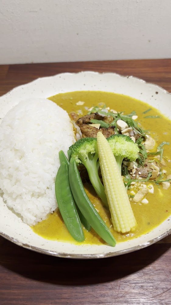 一盤黃咖哩雞肉飯搭配白飯花椰菜玉米筍與甜豆